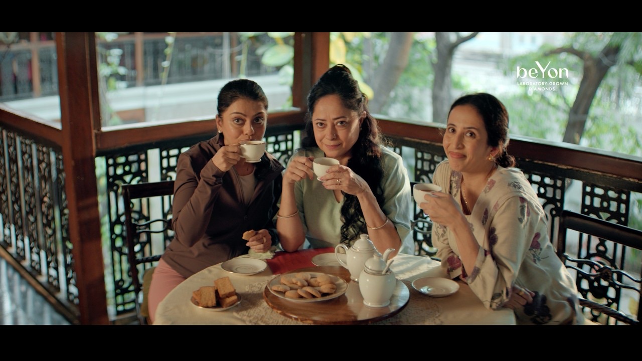 Three women drink tea at a table on a wooden balcony, from the beYon lab-grown diamond festive film 2026