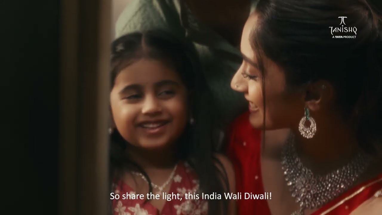 A young girl smiles up at a woman wearing a diamond necklace and earrings, with the subtitle "So share the light, this India Wali Diwali!", Tanishq Middle East 2026