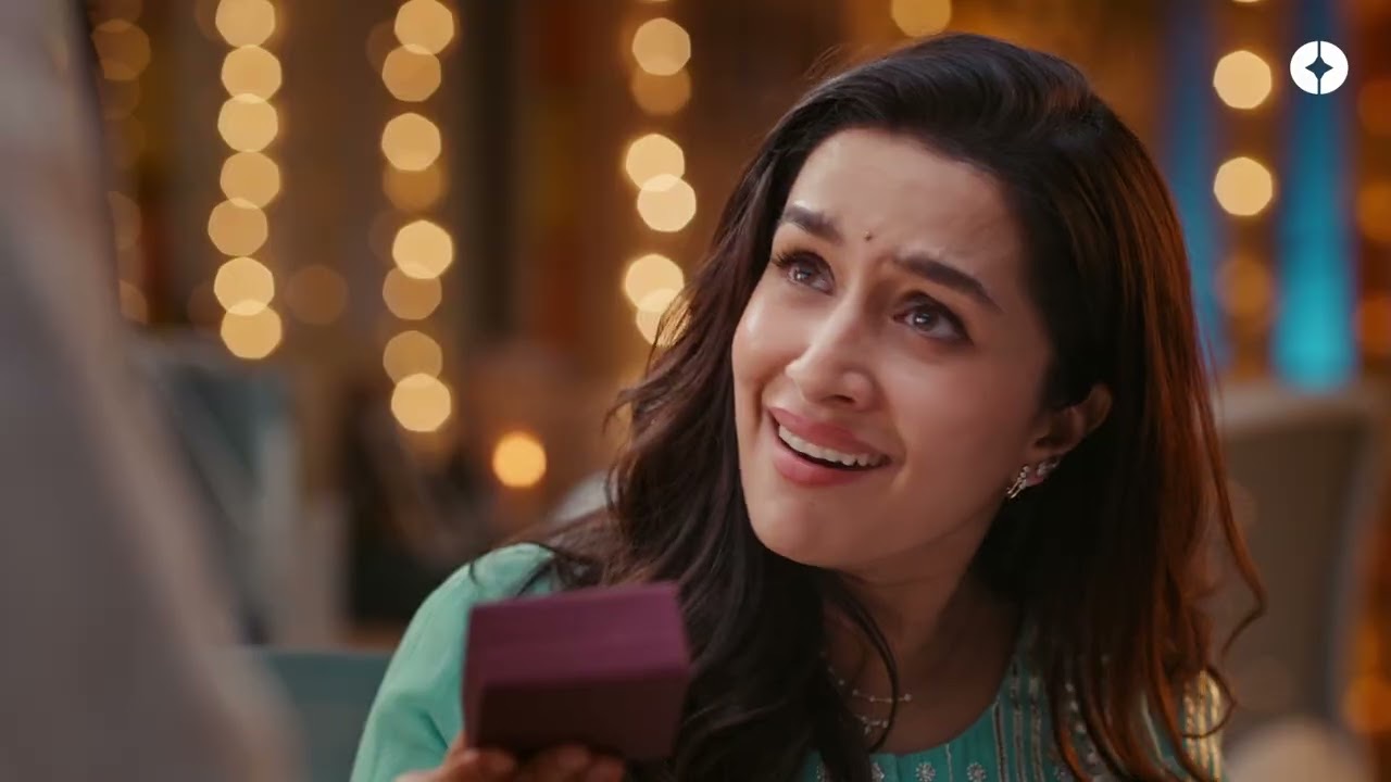 Shraddha Kapoor smiles as she opens a small jewellery box against a background of warm lights, PALMONAS Dhanteras 2026