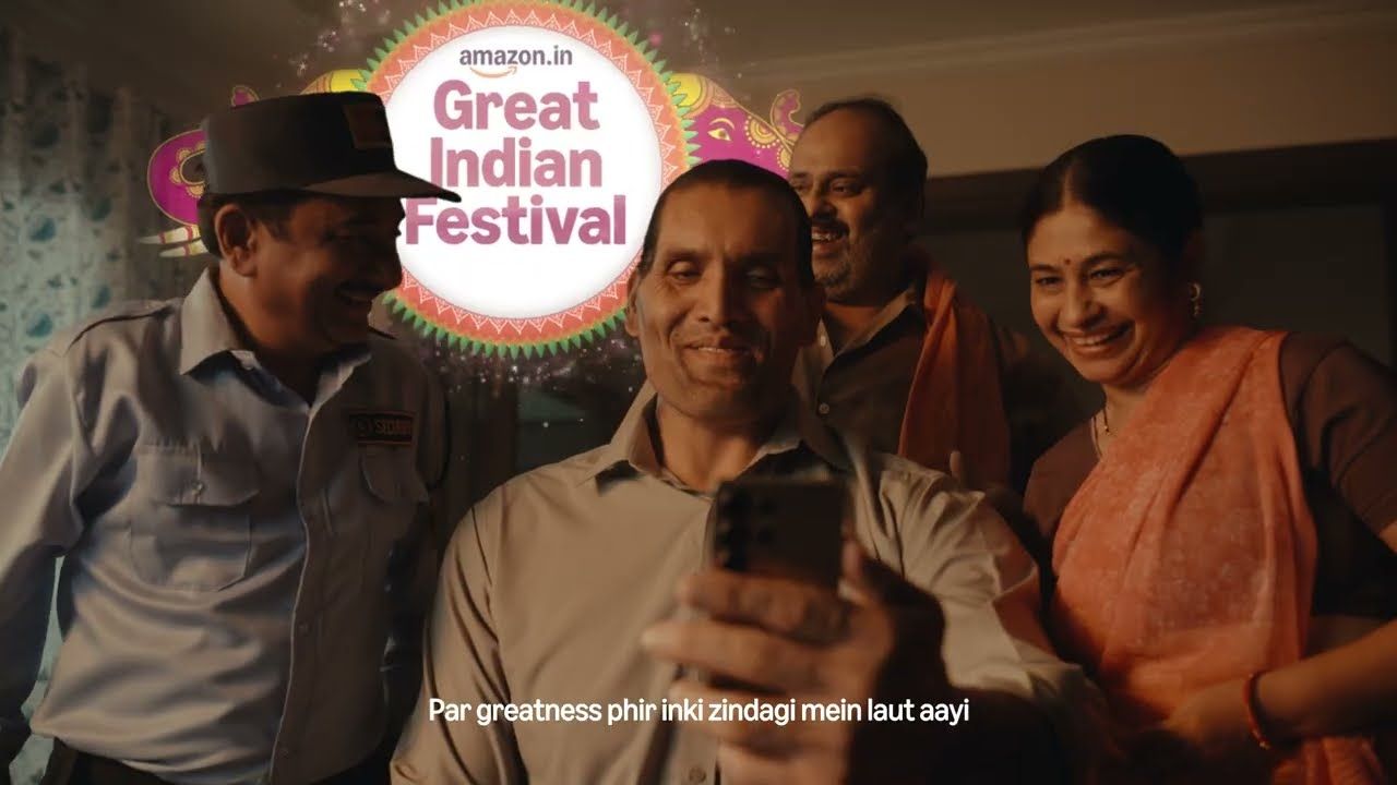 A family gathers around a man taking a selfie under the Amazon Great Indian Festival logo, from Amazon's 2026 film